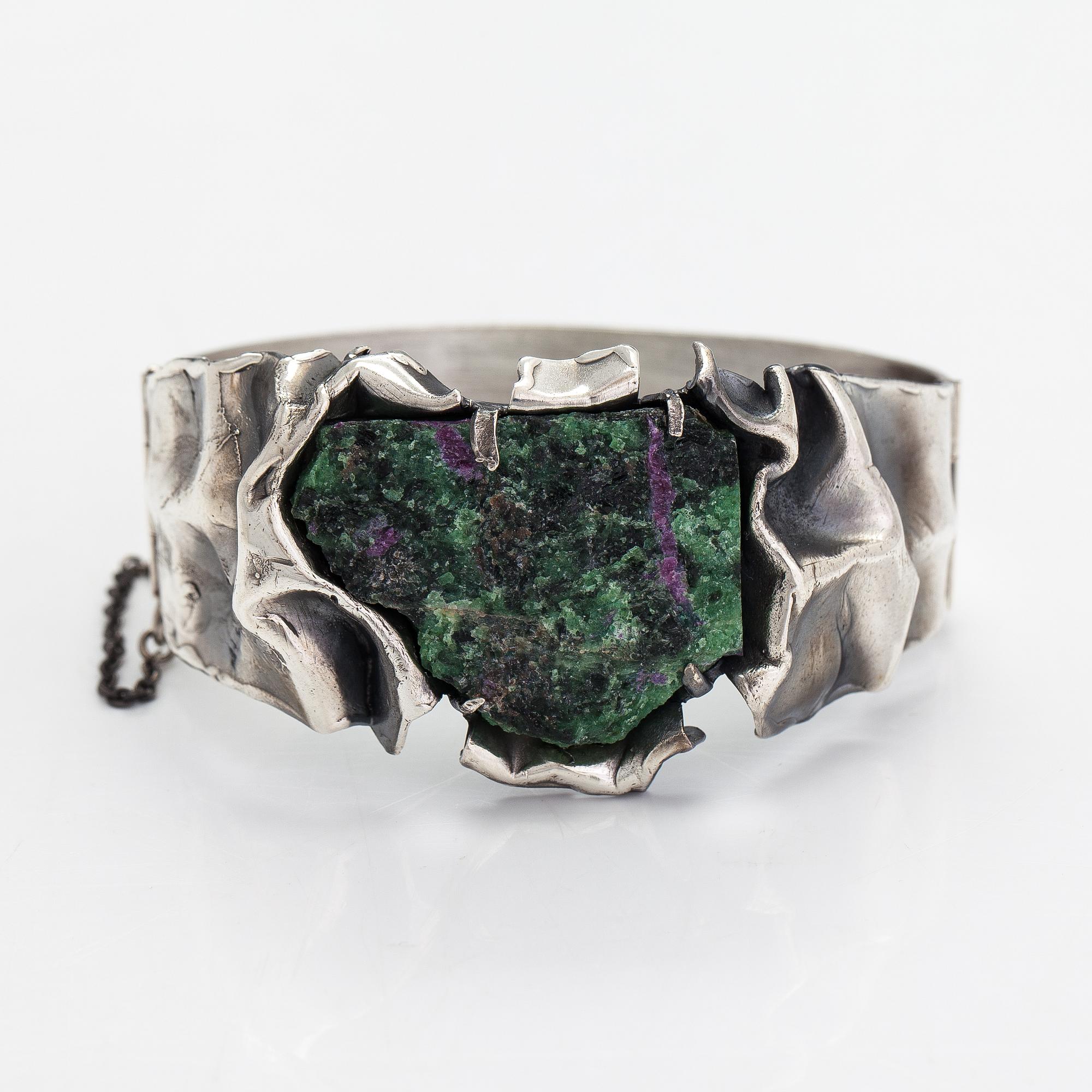 Reino Saastamoinen, Armband "Maahiset", siver och zoisit med rubinkristaller. Helsingfors 1968.