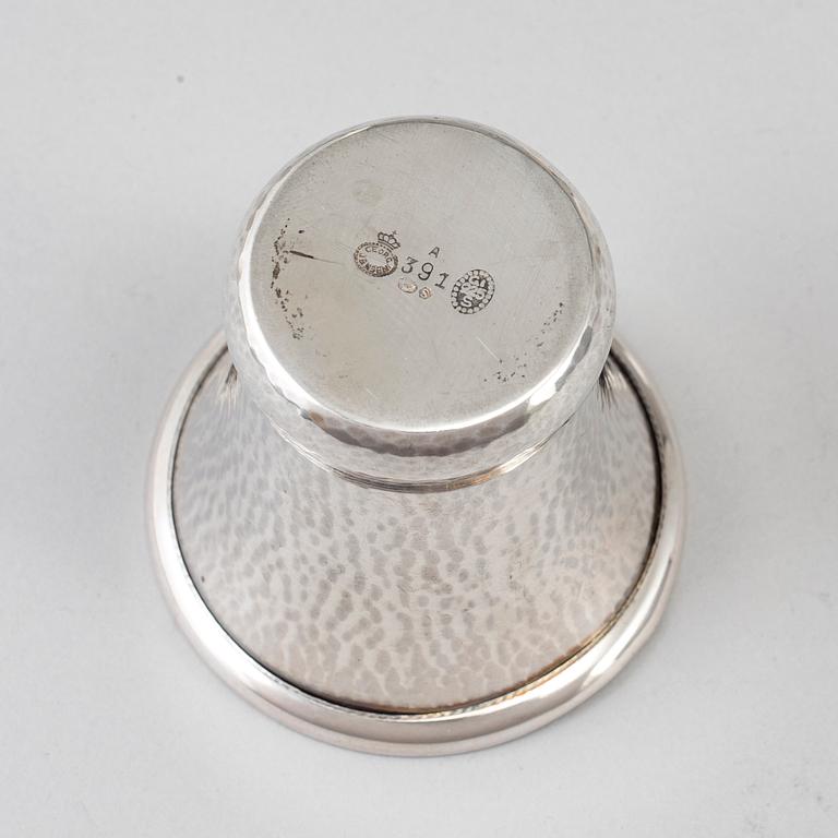 A silver vodkacup, lighter and matchholder.