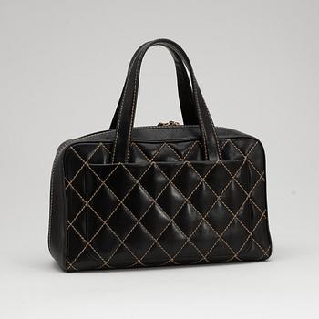 CHANEL, a black leather bag with beige stitching.