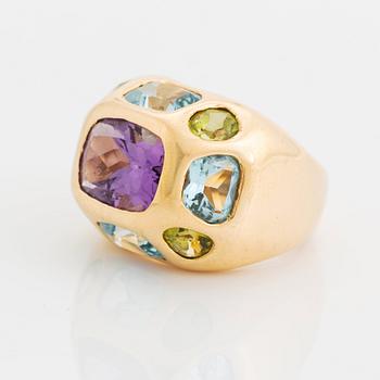 An 18K gold ring set with faceted amethyst, peridot and aquamarine.