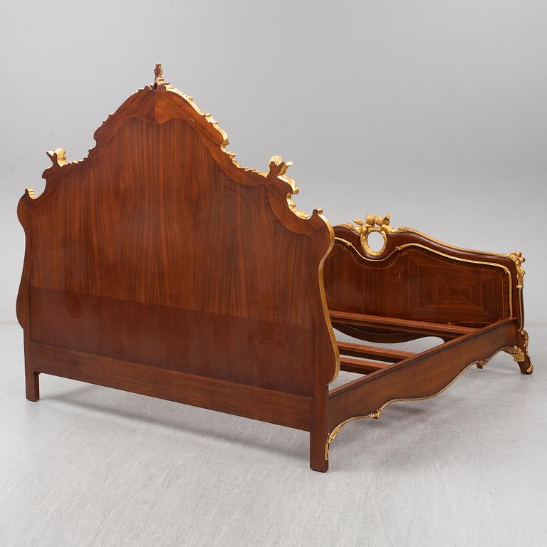 a set of a mahogany veneered and guilded rococo-style bed and two bedside tables.