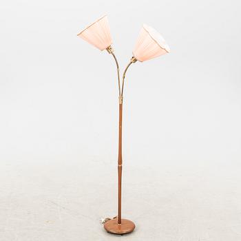 A teak and brass floor lamp from the first half of the 20th century.