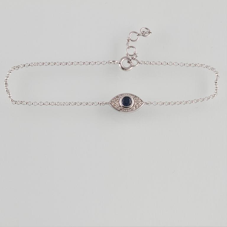ARMBAND, 18K vitguld med briljantslipade diamanter ca 0.09 ct samt fasettslipad blå safir ca 0.18 ct Vikt 1,5 gram.