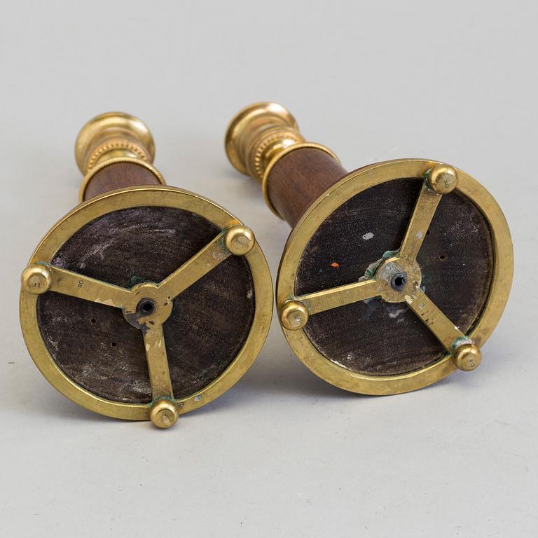 A pair of 20th century mahogany and brass candlesticks.