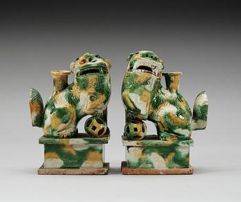 A pair of green and yellow glazed bisquit cencers, in the shape of sitting Buddhist lions, Qing Dynasty, Kangxi (1662-1722).