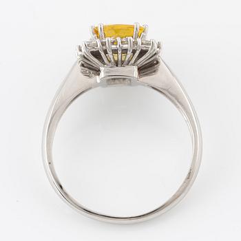 Ring in 18K gold with a yellow faceted sapphire and round brilliant-cut diamonds.