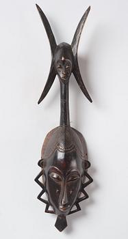 A sculptue and two masks reportedly from The Ivory coast, from the second half of the 20:th century.