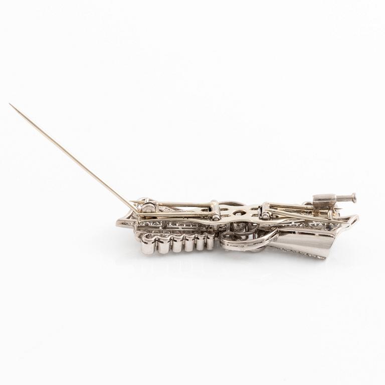 A bow brooch/double clip in 18K white gold set with round brilliant- and eight-cut diamonds.