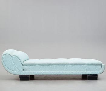 ART DÉCO, an upholstered daybed on shaped black lacquered wooden legs, 1920's-30's.