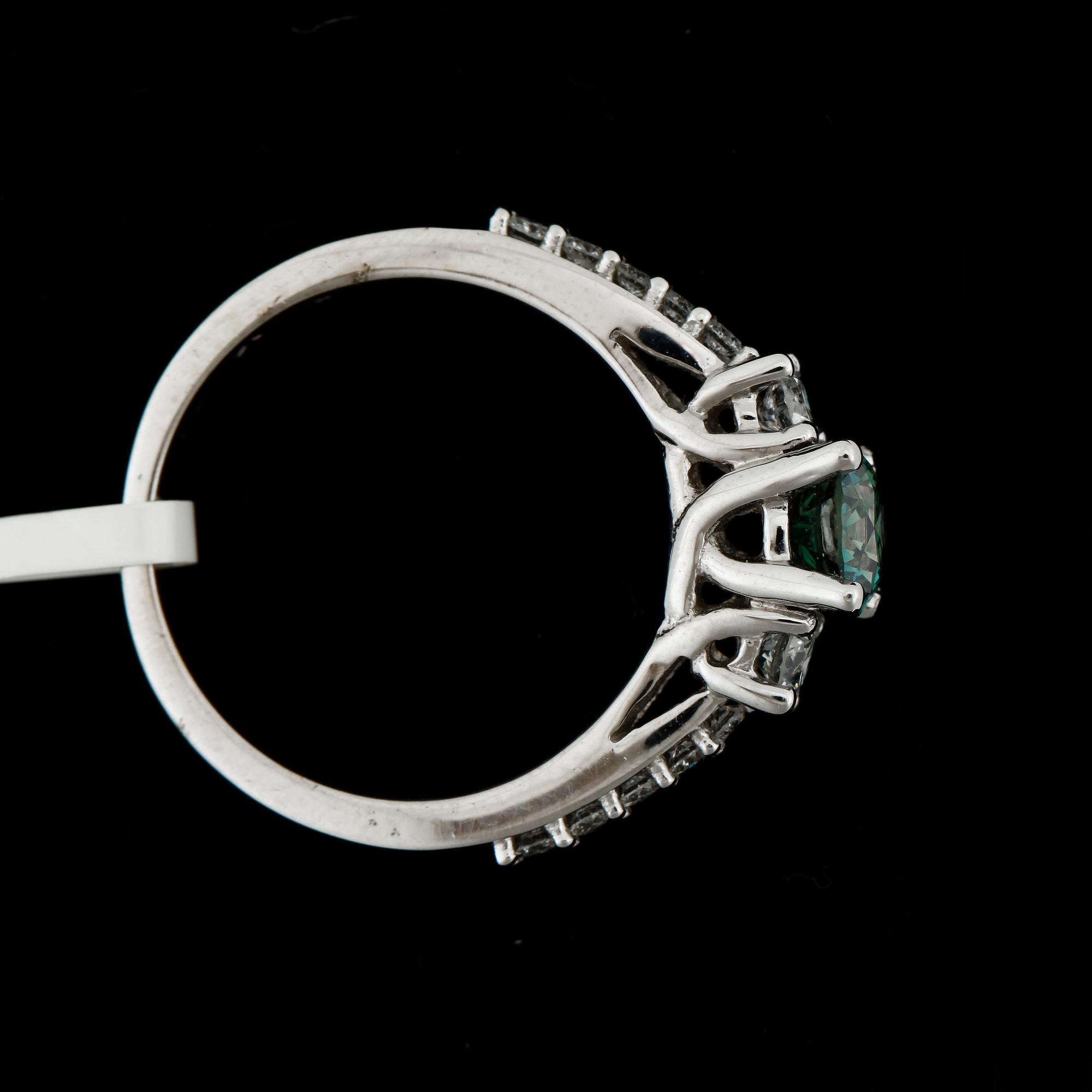 RING, 18k vitguld med mittsten grön briljantslipad diamant ca0,73ct o briljantslipade diamanter tot ca0,40ct. Vikt 4,7g.