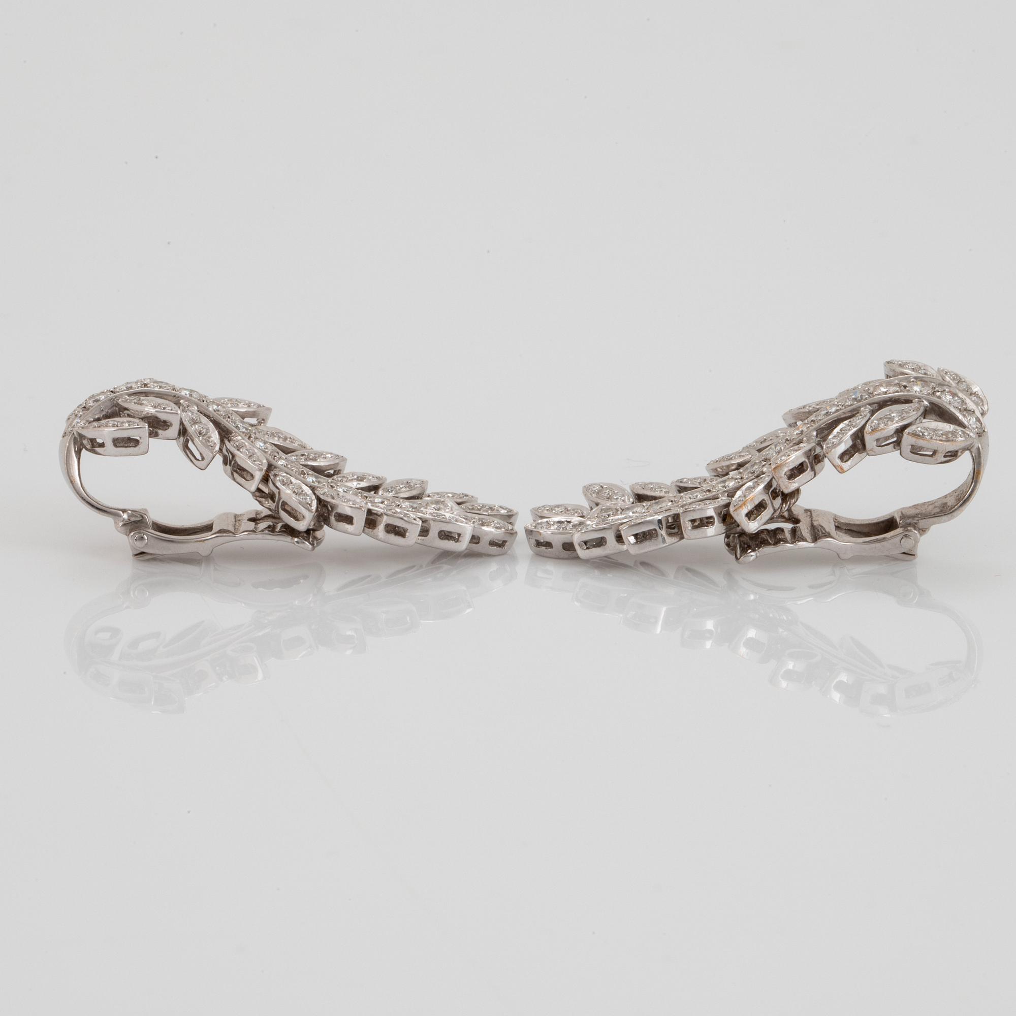 A pair of 18K white gold earrings set with round brilliant-cut diamonds.