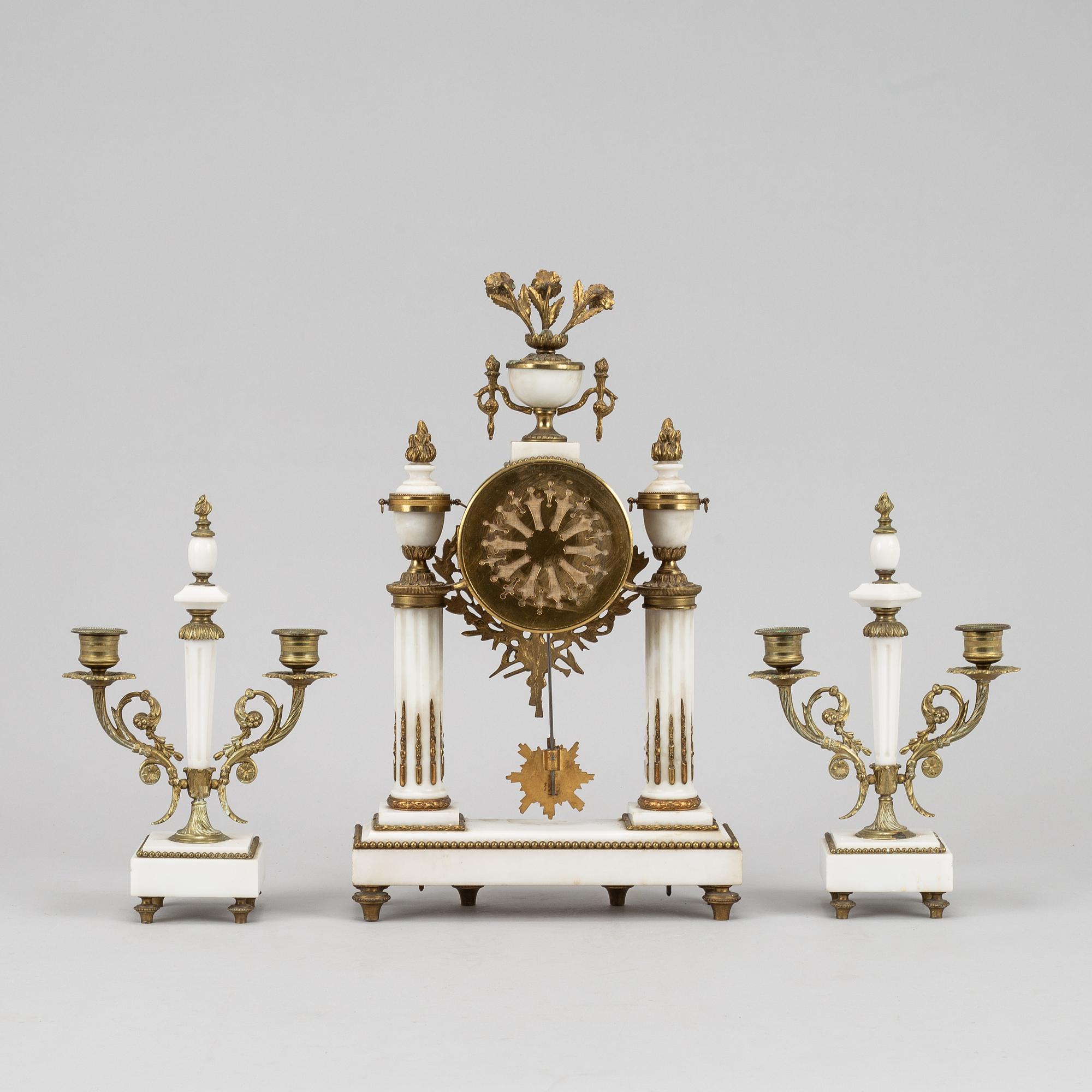 A Louis XVI style pendulum clock and a pair of candelabra, early 20th century.