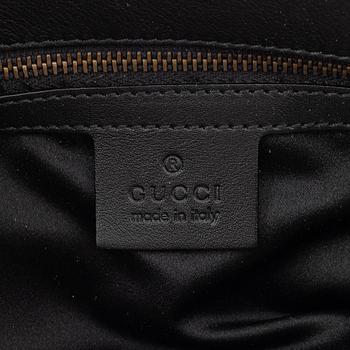 Gucci, a black leather handbag.