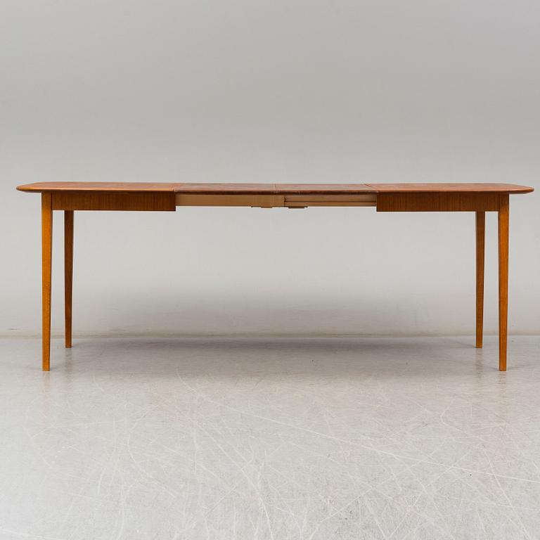 A late 20th Century teak veneered dinner table.