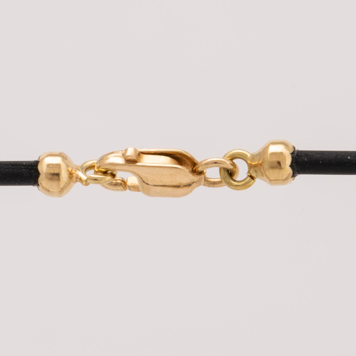 Hänge på latex, 18K med briljanter ca 0,03 ct, längd ca 40 cm, hänge ej avtagbart.