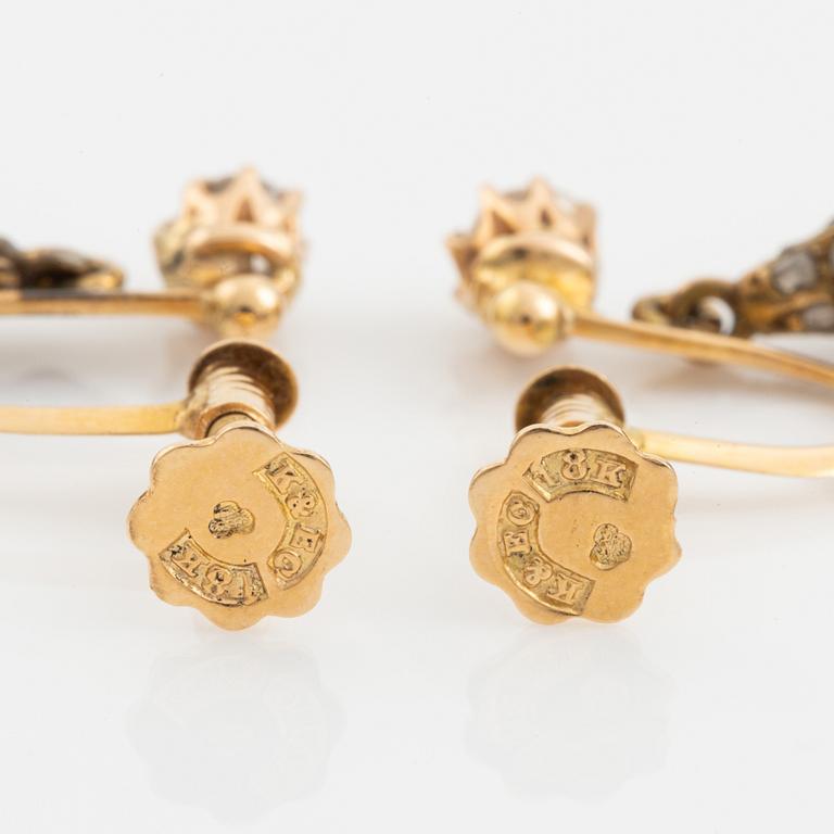Ett par örhängen 18K guld med droppformade pärlor.
