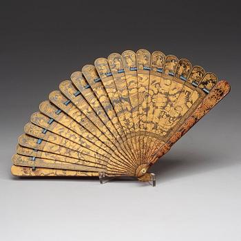 A black lacquer and gold fan in a silk clad box, Qing dynasty, 19th Century.
