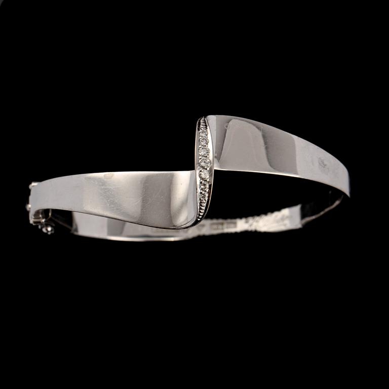 ARMRING, 18k vitguld med 7 briljantslipade diamanter, tot 0.17 ct, KE Palmberg, Alton, Falköping, 1975. Vikt 21 g.