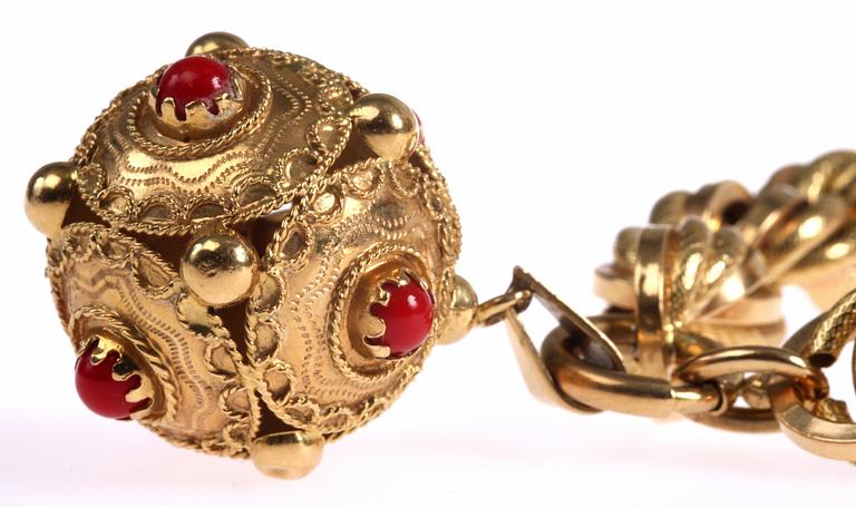 ARMLÄNK MED HÄNGE, 18K guld samt röda stenar. Utländska stämplar. Vikt 48 gram.