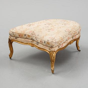 A Louis XV-style bergère armchair with stool, second half of the 19th century.