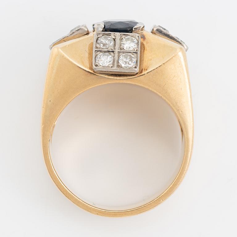 An 18K gold ring set with a faceted sapphire and diamonds.