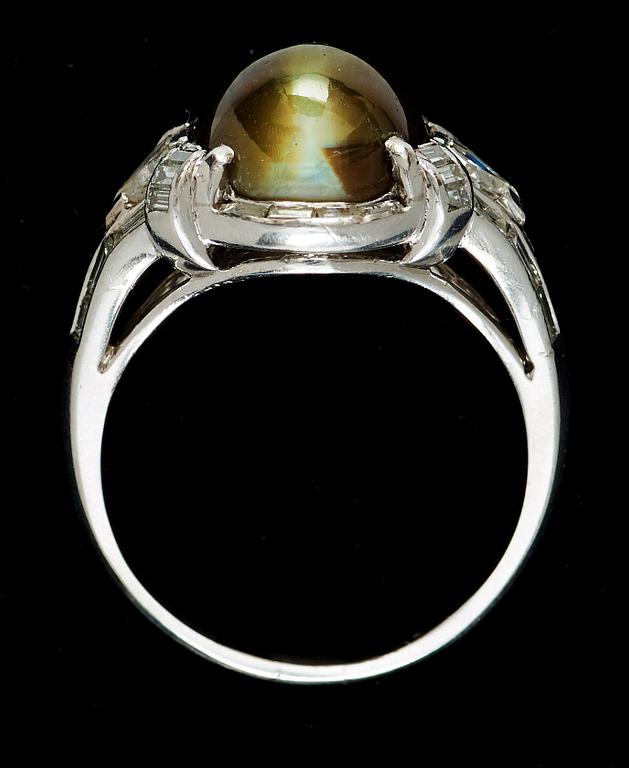 A 6.75 cts cabochon-cut chrysoberyl cat's-eye and diamond ring. Diamonds total carat weight circa 1.00 ct.