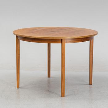 A round walnut veneered dining table.