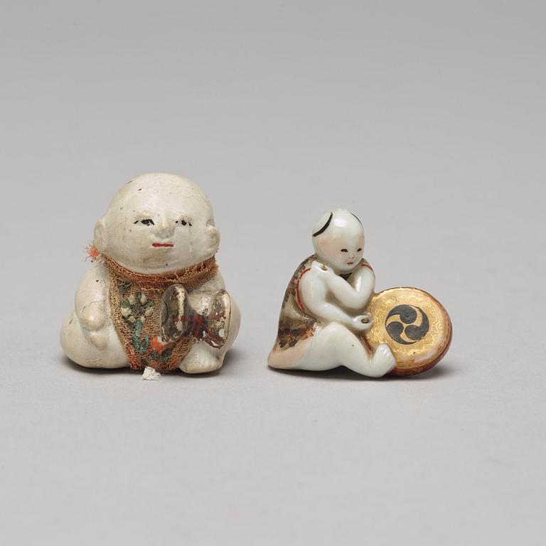 A set of two Japanese figures and a set of six cups in a wooden box, early 20th Century.