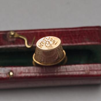 Three early 19th century gold pieces: Snuff-box, case with tooth-picker and button.