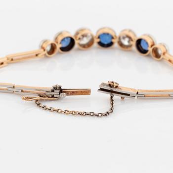 An 18K gold bracelet set with sapphires and old-cut diamonds.