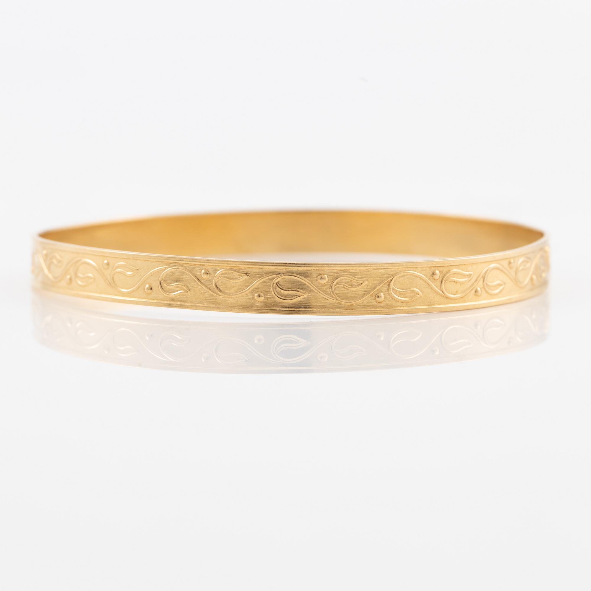 Arm ring, 18K gold with stylised decoration.
