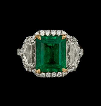 957. A emerald, 5.50 cts, ring. Flanked by circa 2.35 cts of diamonds.