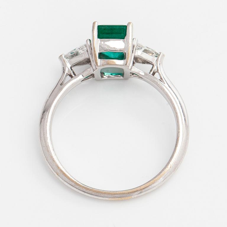 An 18K white gold ring, set with a Zambian emerald and trillion-cut diamonds.