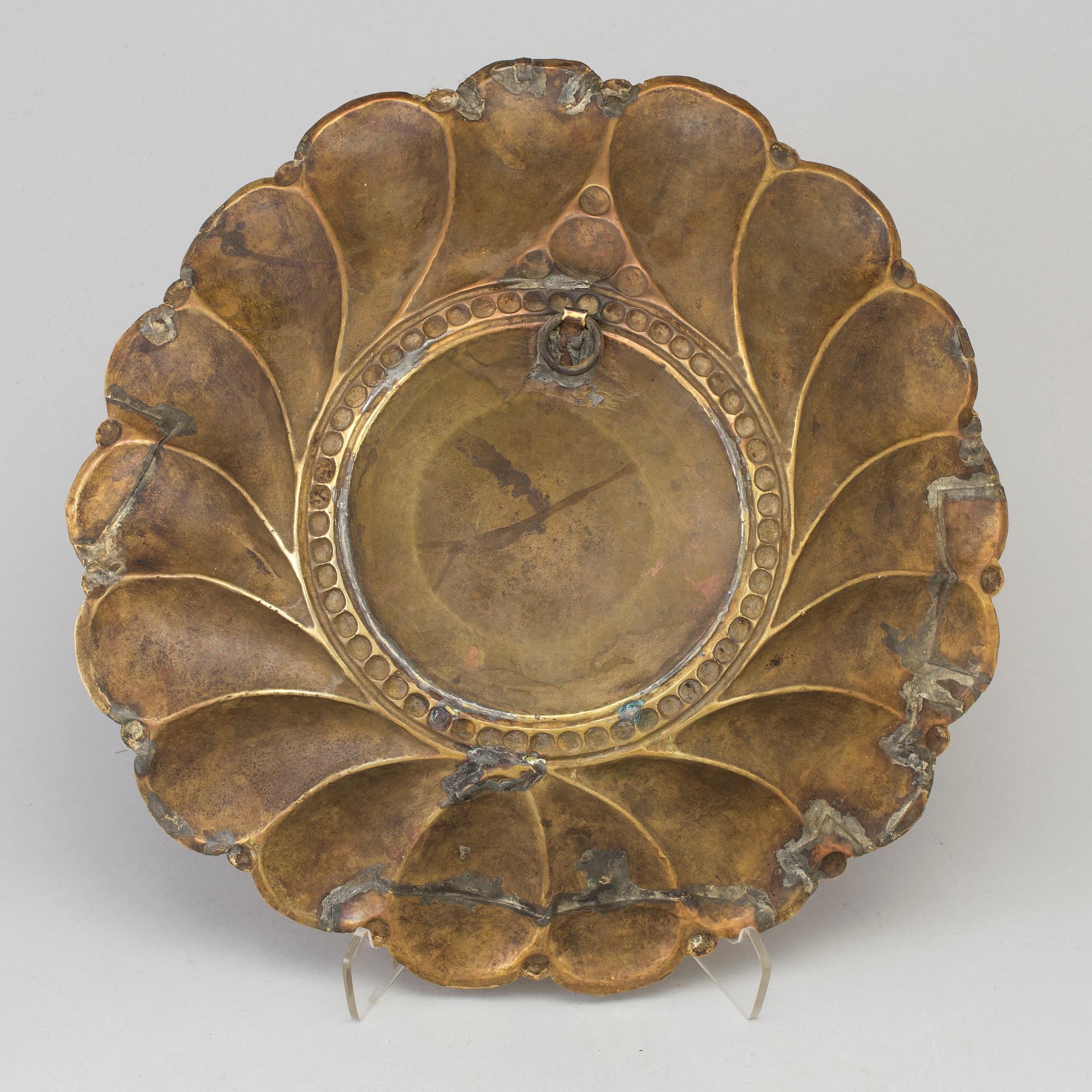 A 17th century brass wall plaque.