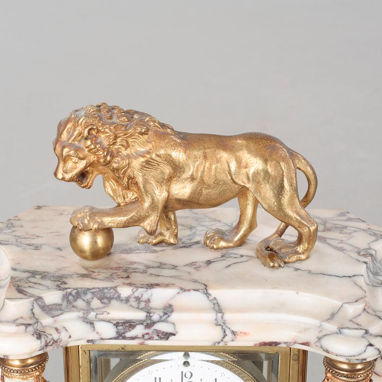 A Louis XVI style table clock and two urns, around the year 1900.