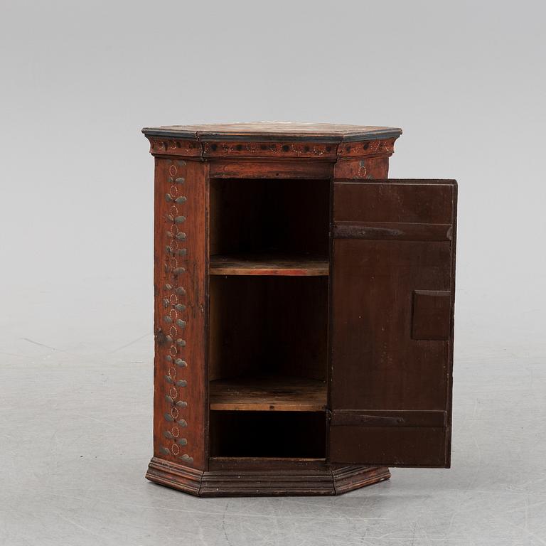 A Swedish painted corner cabinet, dated 1825.