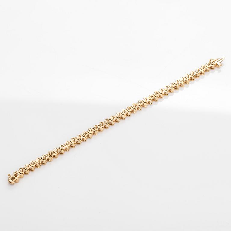 A 14K gold tennis bracelet, with brilliant-cut diamonds.