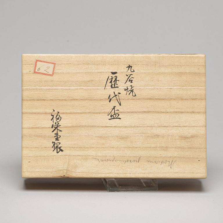 A set of two Japanese figures and a set of six cups in a wooden box, early 20th Century.