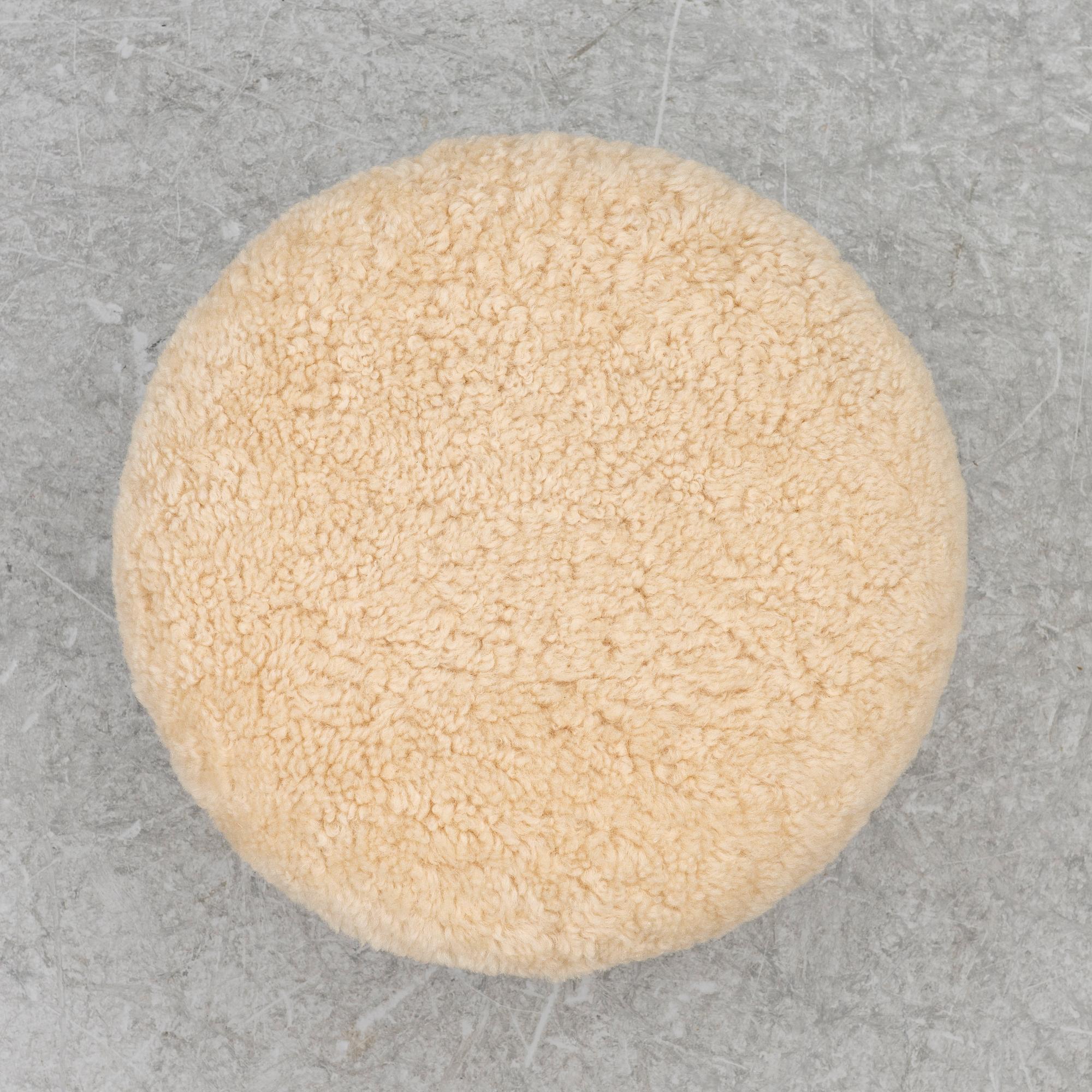 A contemporary stool with birch legs and new sheepskin upholstery.