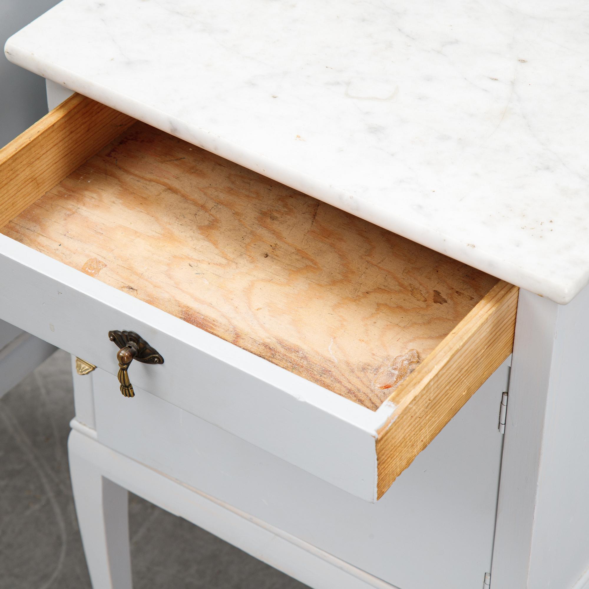 A pair of painted bedside tables with marble tops, 1920's.