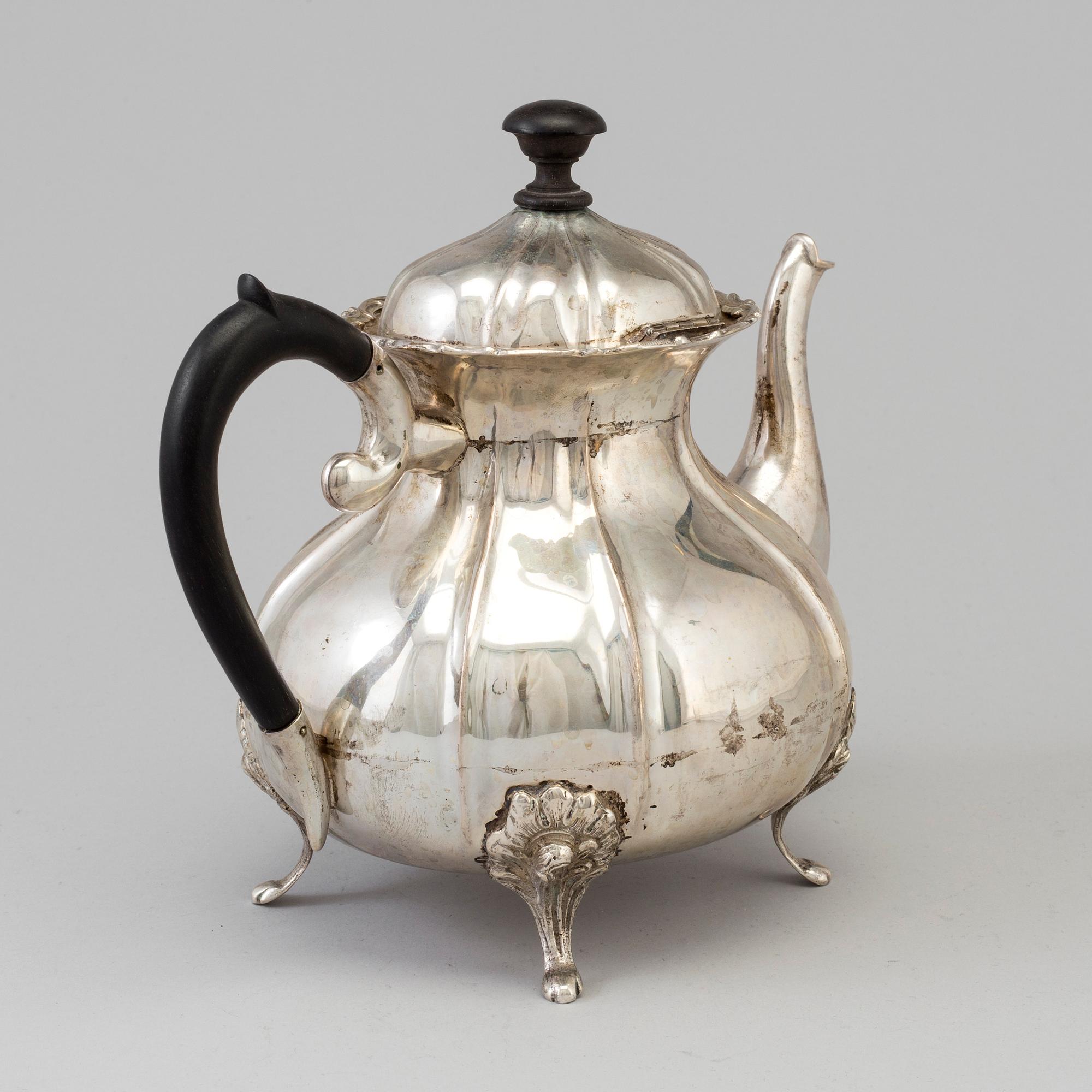 A silver rococo style teapot.