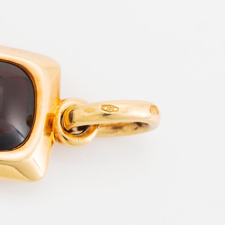 An 18K gold and garnet Pomellato cross.
