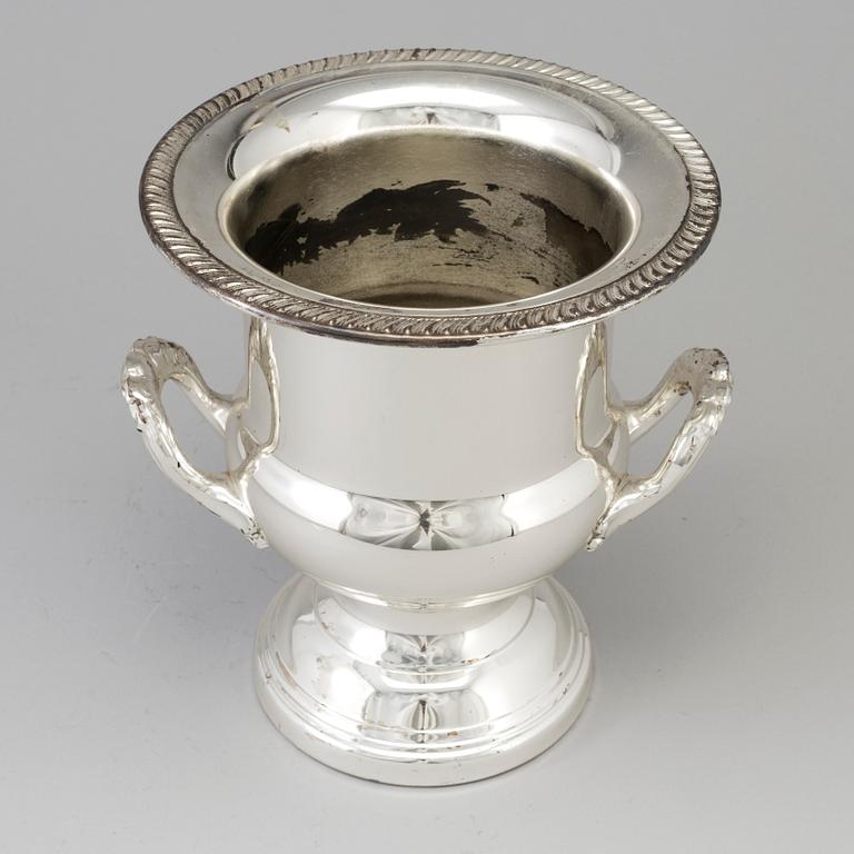 A 20TH CENTURY SILVERVED METAL CHAMPAGNE COOLER.