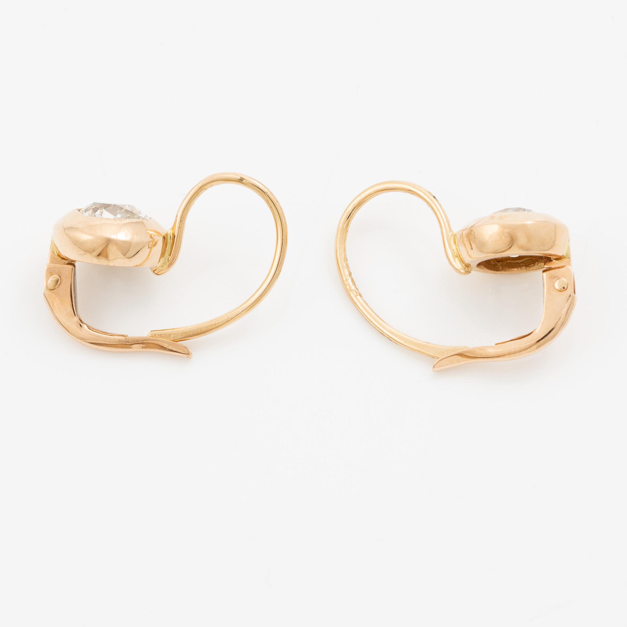 A pair of earrings in 18K gold set with two old-cut diamonds.