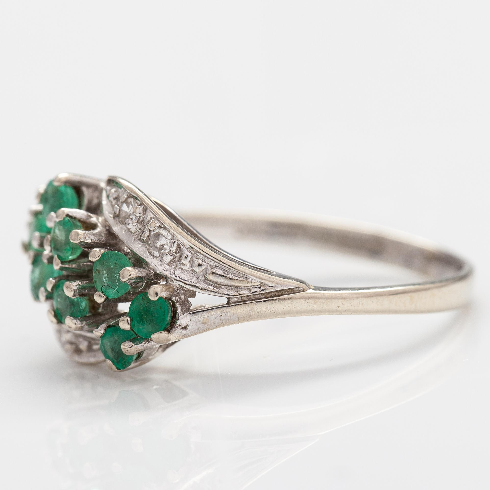 A 14K white gold ring with emeralds and diamonds ca. 0.02 ct in total. Import marked Turun Hopea, Turku 1995.