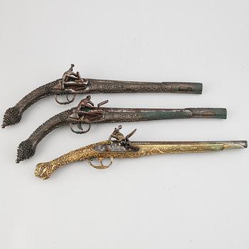 A pair of miquelet pistols and an flintlock pistol, 18/19th Century.