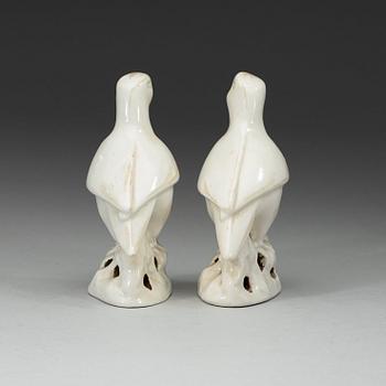 A pair of white and red glazed figures of parrots, late Qing dynasty.