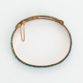 A silver and turquoise bracelet.