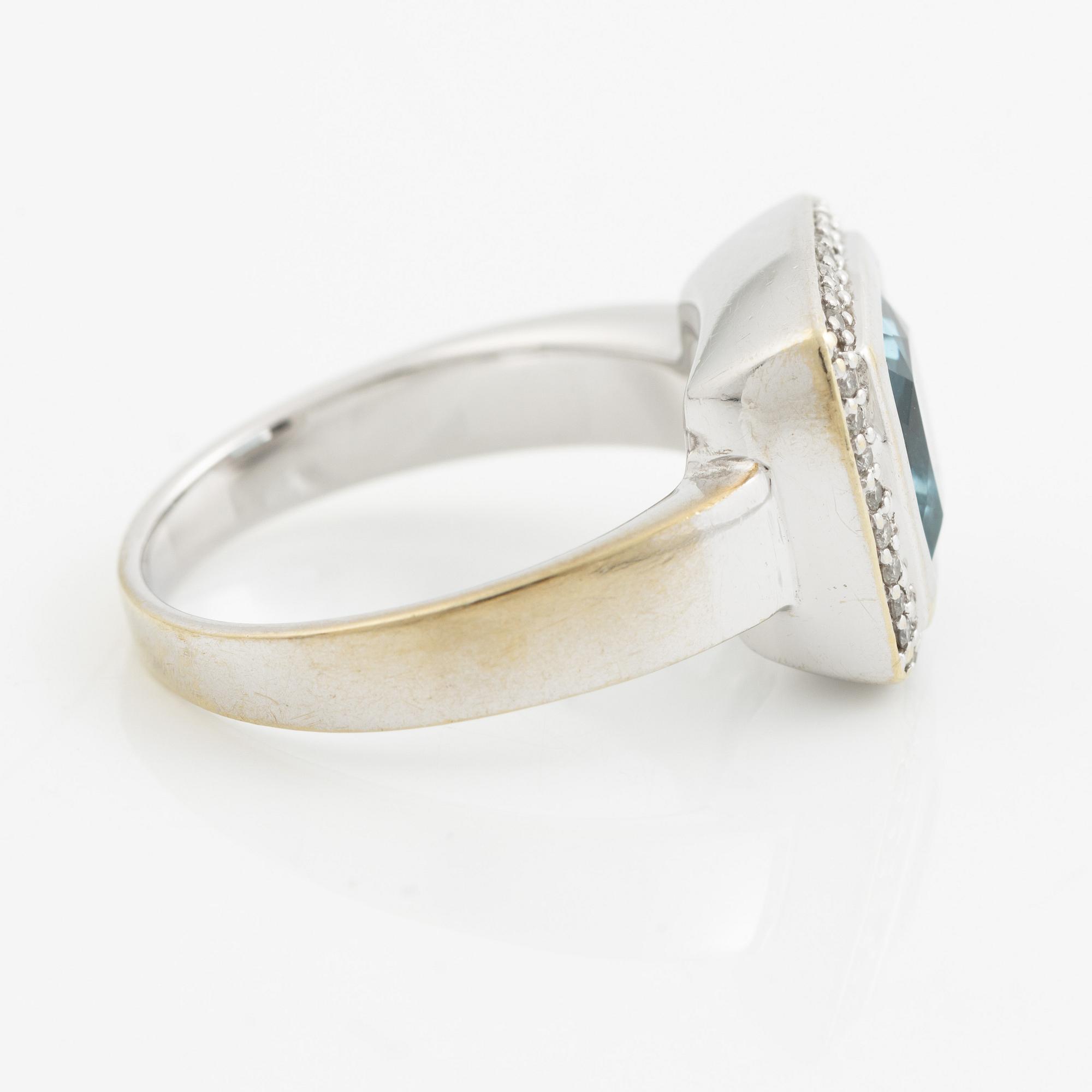 Ring 18K vitguld med en fasettslipad topas och runda briljantslipade diamanter.