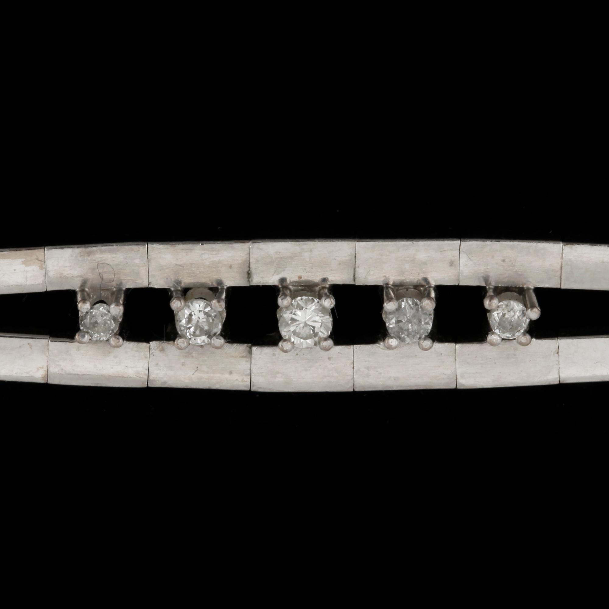 ARMBAND, 18k vitguld med 5 briljantslipade diamanter tot ca 0,21 ct. Vikt ca 23 gram.